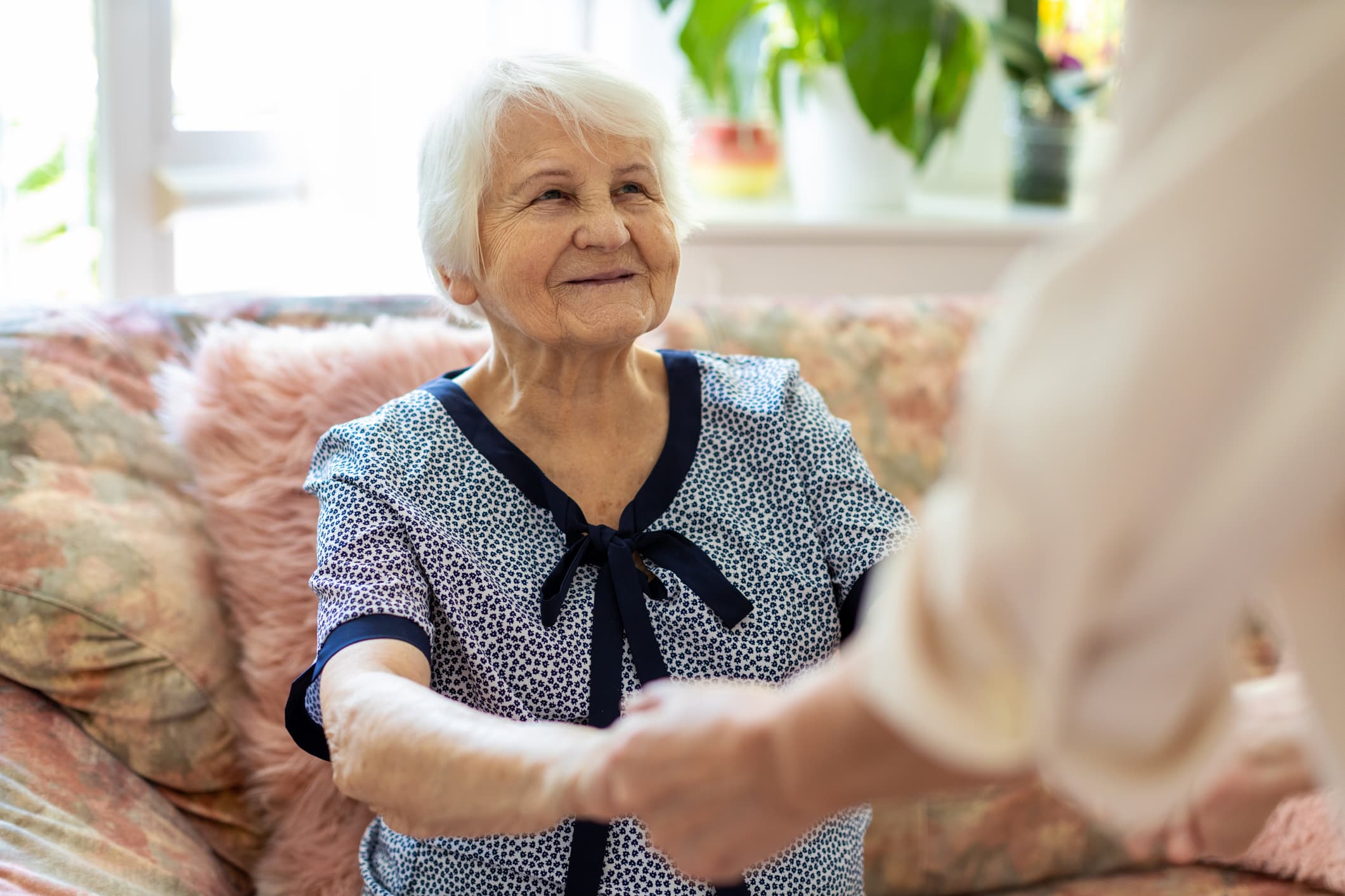 A caregiver helping a senior showing early signs of Alzheimer’s Disease.