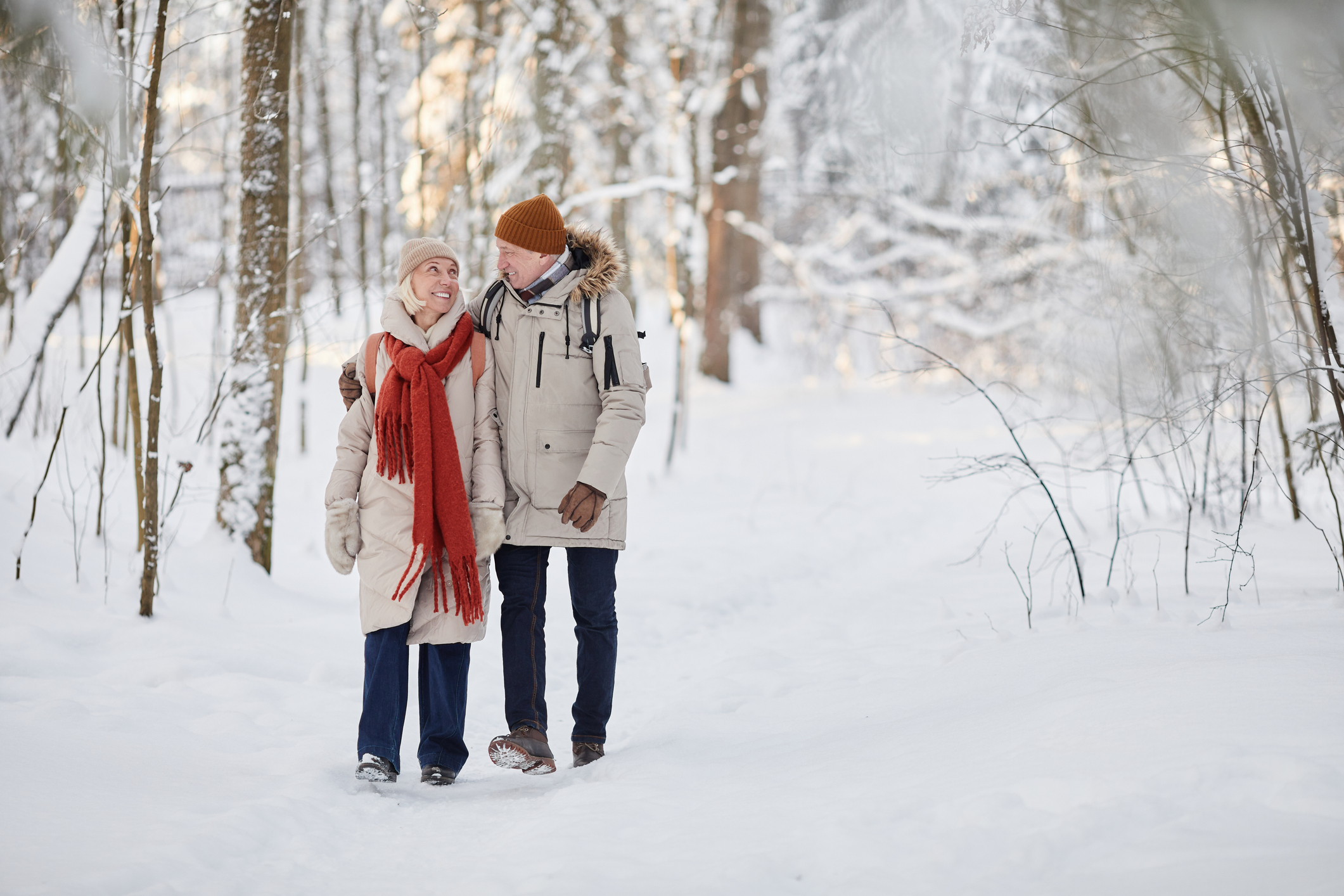 A senior couple walking safely in the winter to prevent falls.